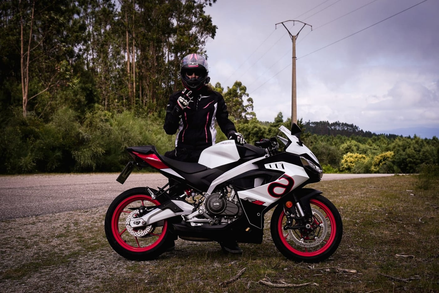 Marta con su moto en una carretera de Galicia